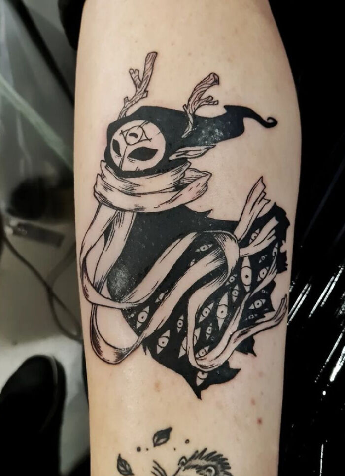 Trippy Little Forest Spirit arm tattoo with swirling patterns and eyes, showcasing unique design elements.