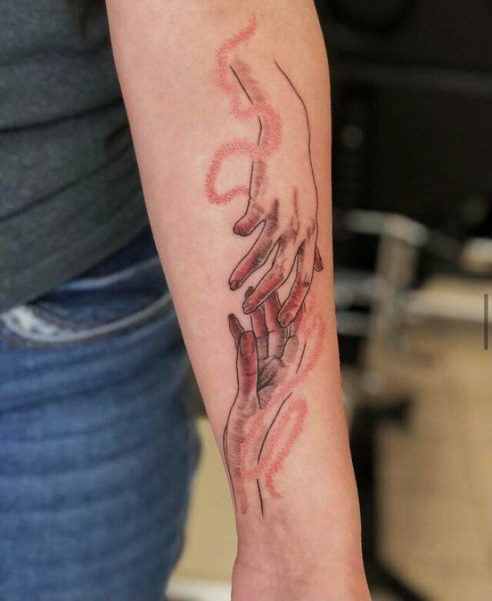 Forearm tattoo featuring abstract hands and psychedelic patterns.