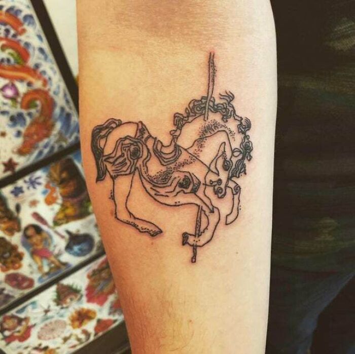 "Trippy tattoo of a distorted carousel horse on a forearm, creating a mind-bending visual effect."