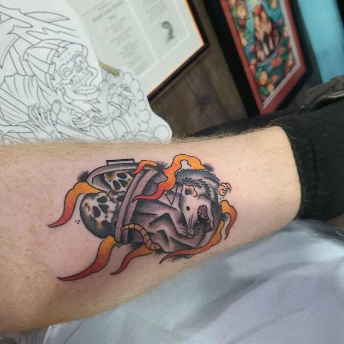 Trippy tattoo of a rat in a surreal design with vibrant colors on an arm.