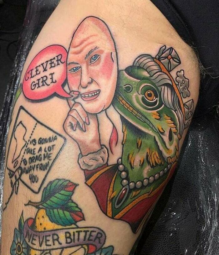 Trippy tattoo of Queen E-Lizard-Beth depicting a human face with a lizard's body and whimsical text on a leg.