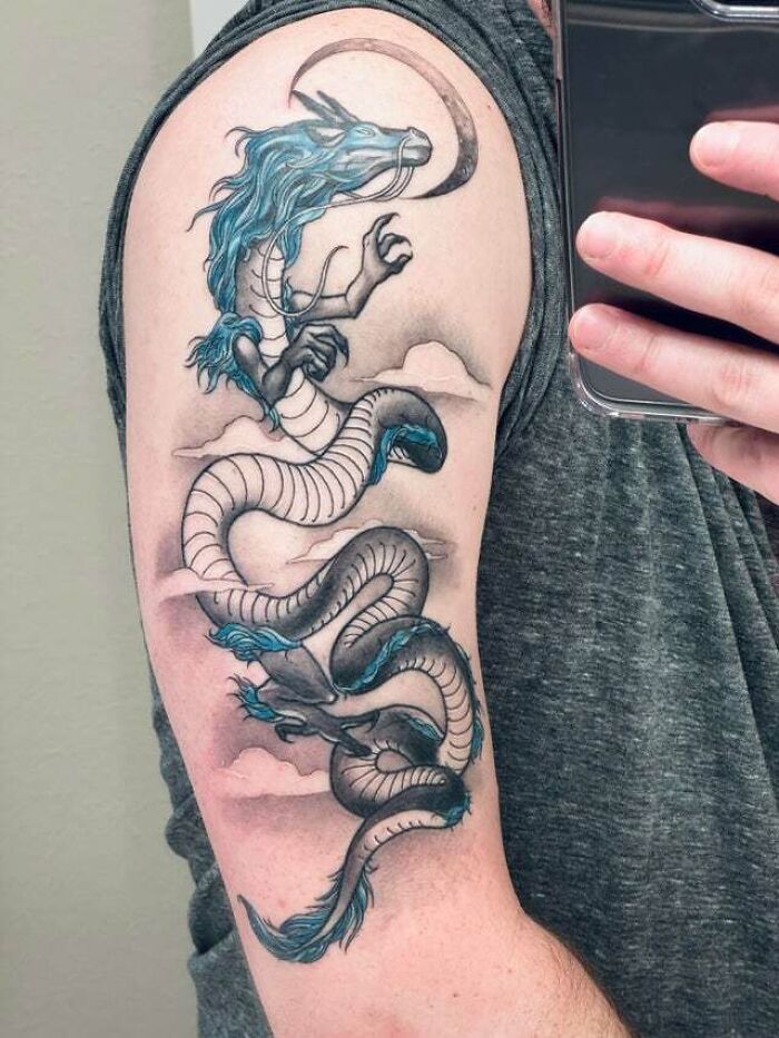 Trippy tattoo of a mythical dragon with blue accents on an arm, showcasing psychedelic art style.