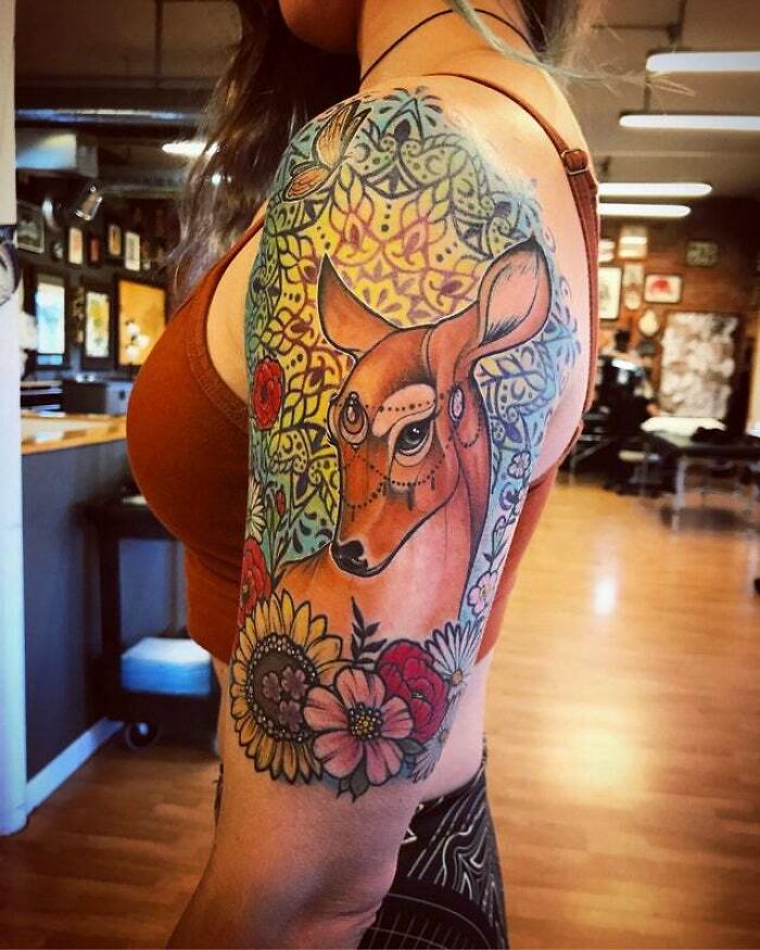 Colorful trippy tattoo of Bambi with flowers on shoulder arm sleeve.