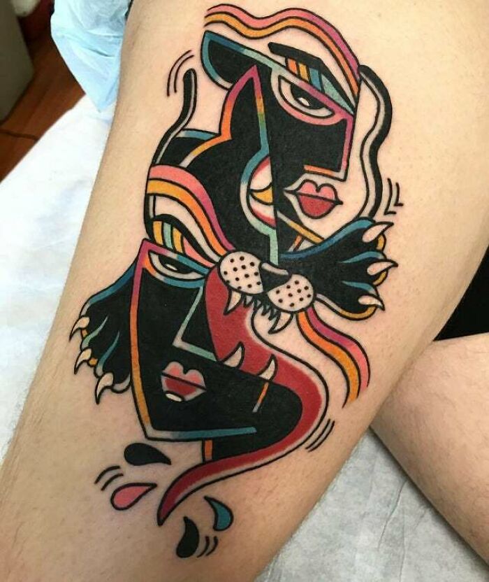Trippy deconstructed panther faces tattoo on leg with bold, colorful geometric shapes.