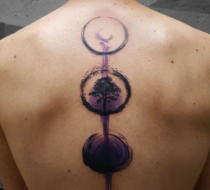 Back spine tattoo depicting the cycle of life and death, featuring celestial and nature elements, embodying trippy tattoo art.