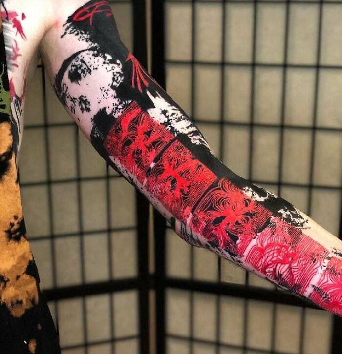 Arm with trippy tattoos featuring abstract black and red designs against a patterned background.