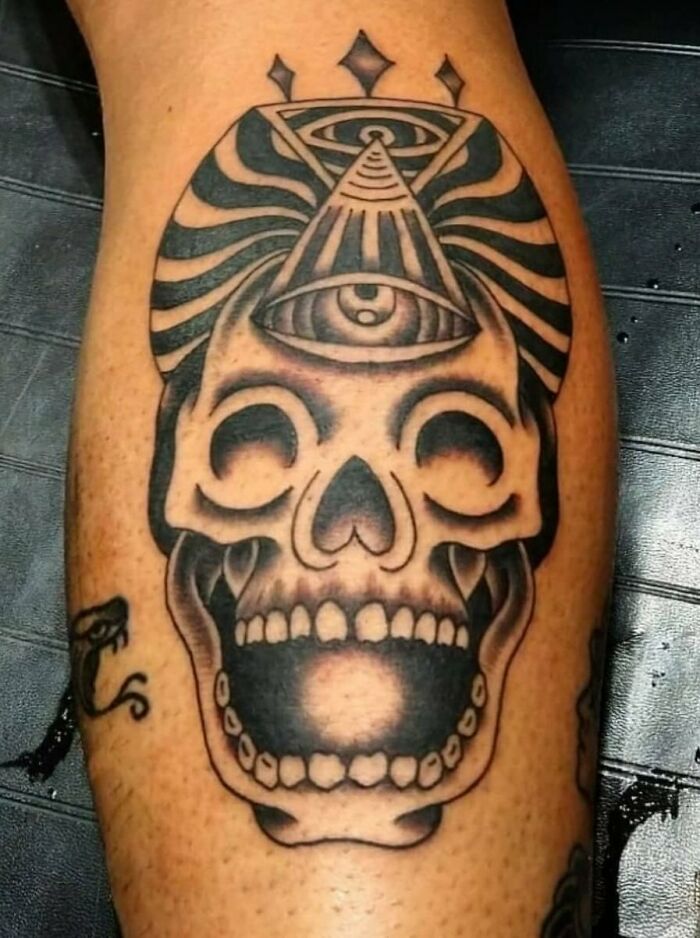 Skull with eyes tattoo on leg showcasing a trippy design.