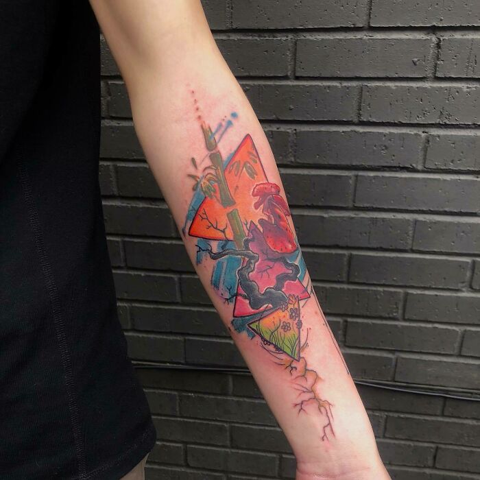Forearm with a colorful, abstract psychedelic tattoo design featuring geometric shapes and vibrant colors.