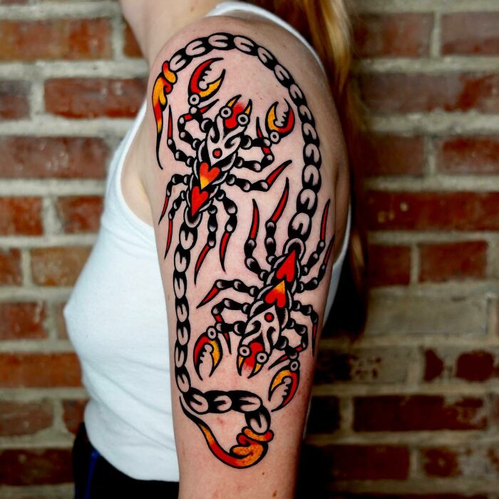 Colorful trippy tattoo of scorpions on arm and shoulder against a brick wall background.