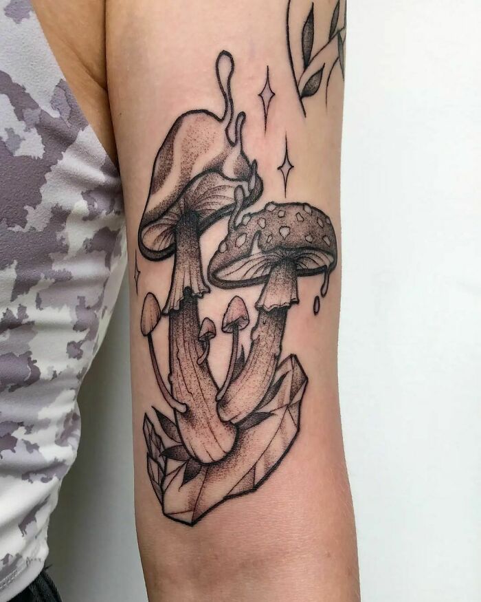 Psychedelic art tattoo of trippy, melting mushrooms on an arm.