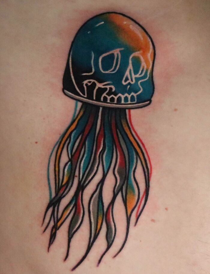 Colorful trippy tattoo of a jellyfish with a skull design, featuring vibrant hues and flowing tentacles.