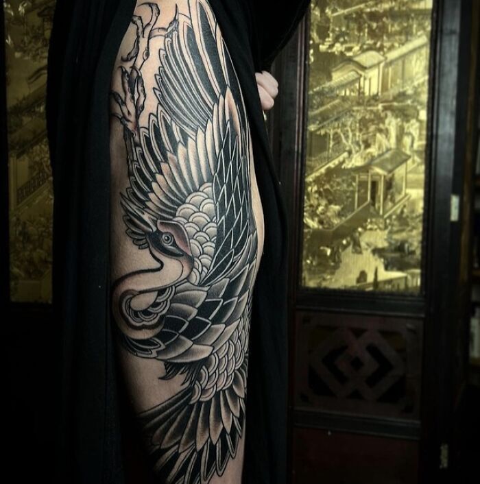Close-up of a detailed trippy tattoo featuring a stylized bird design on a person's leg.