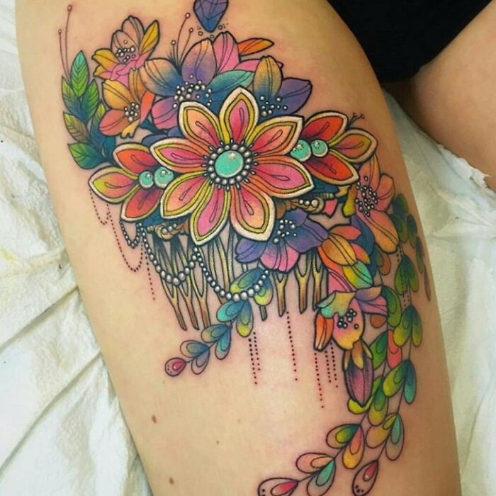 Colorful psychedelic art tattoo of vibrant flowers and flowing patterns on a person's skin.