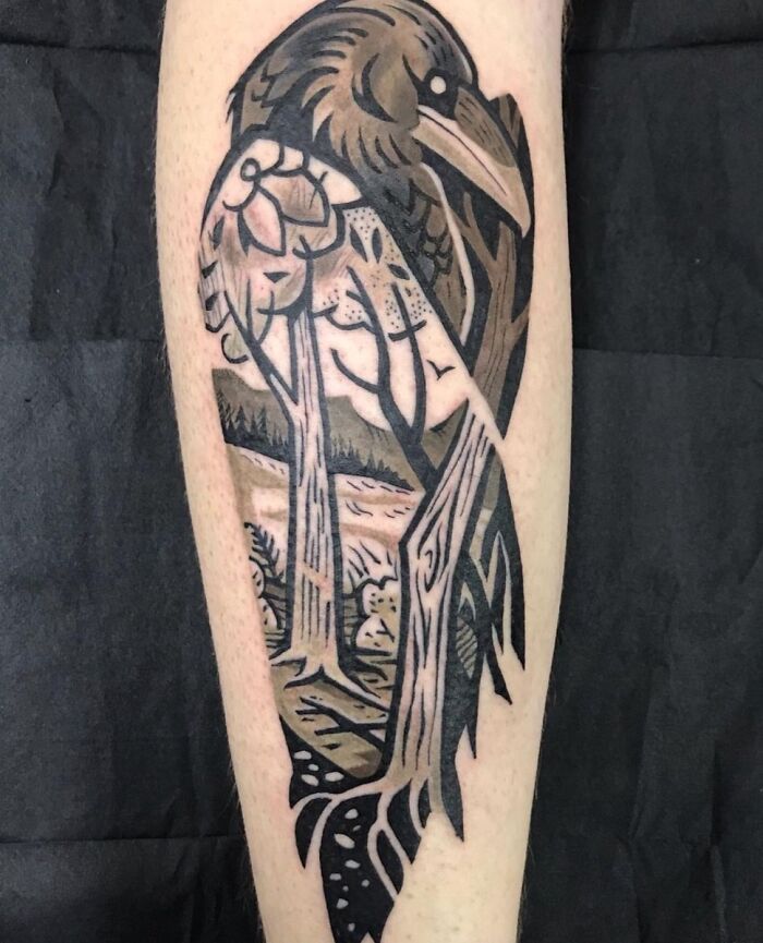 Trippy tattoo of a crow with tree and landscape elements, optical illusion design on the forearm.