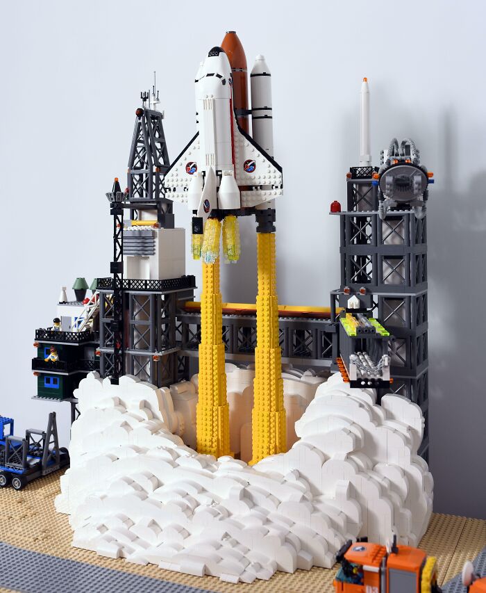 LEGO builds of a space shuttle launching with detailed smoke and launch tower, showcasing incredible LEGO art and creativity.