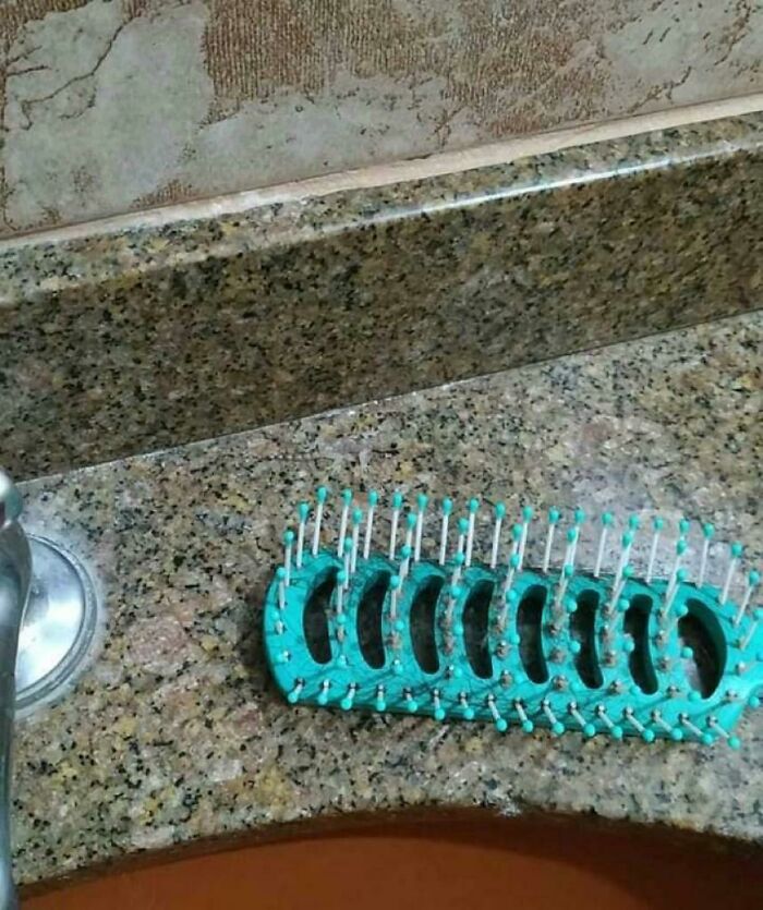 Hairbrush perfectly camouflaged on a speckled granite bathroom countertop, blending in with the background.