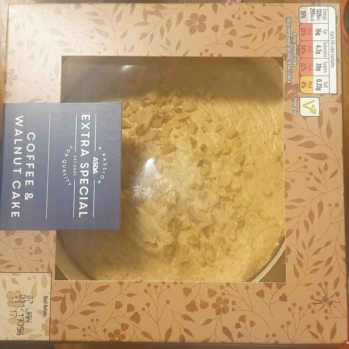 Coffee and walnut cake in a floral patterned box with a label reading extra special for quality, blending with the background.