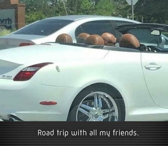 White convertible car with leather seats parked closely to a silver car, illustrating perfectly camouflaged things.