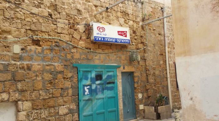 Old stone building with camouflaged blue door blending into the wall, illustrating perfectly camouflaged things to find.