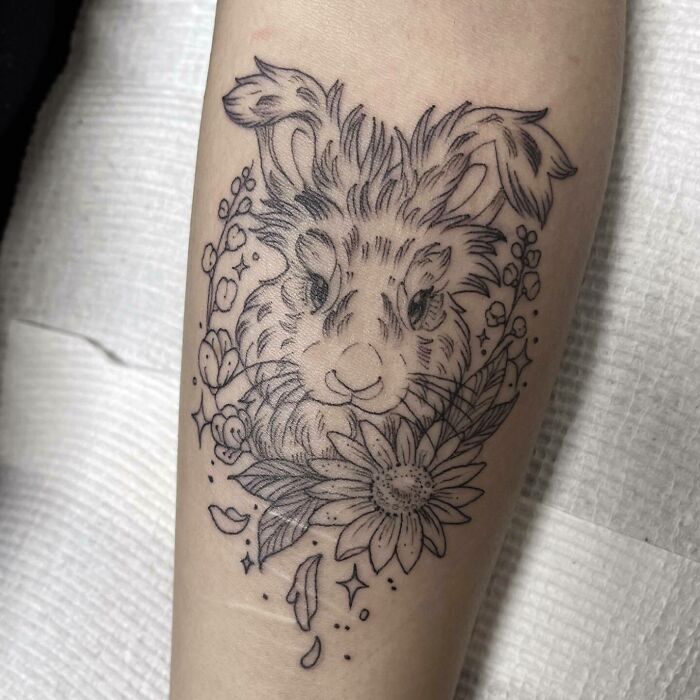 Rabbit tattoo design celebrating furry friends, with floral accents on forearm.