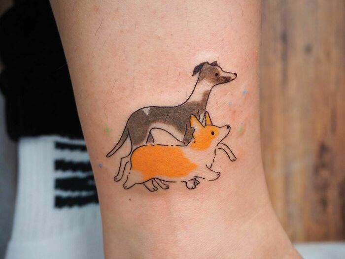 Pet tattoos of two dogs on skin, celebrating furry friends.