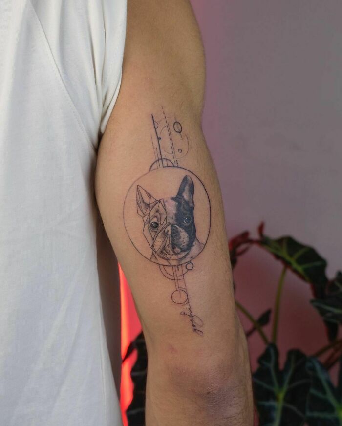 Tattoo of a dog's face on a person's arm, featuring intricate geometric designs, symbolizing an adorable pet.