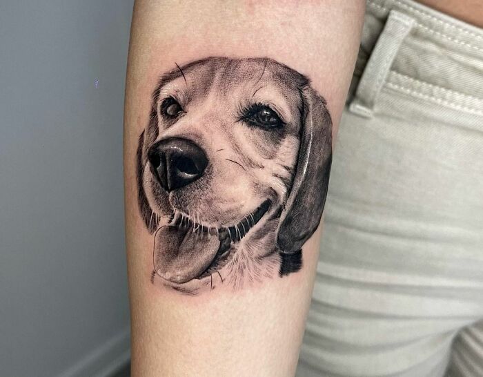 Realistic dog tattoo on arm celebrating a furry friend.