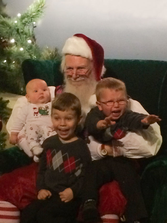 Children posing with Santa, creating a funny Christmas card moment.