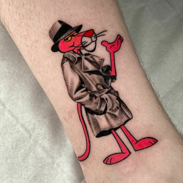 Cartoon tattoo of a pink panther character in a trench coat, capturing a nostalgic childhood favorite.