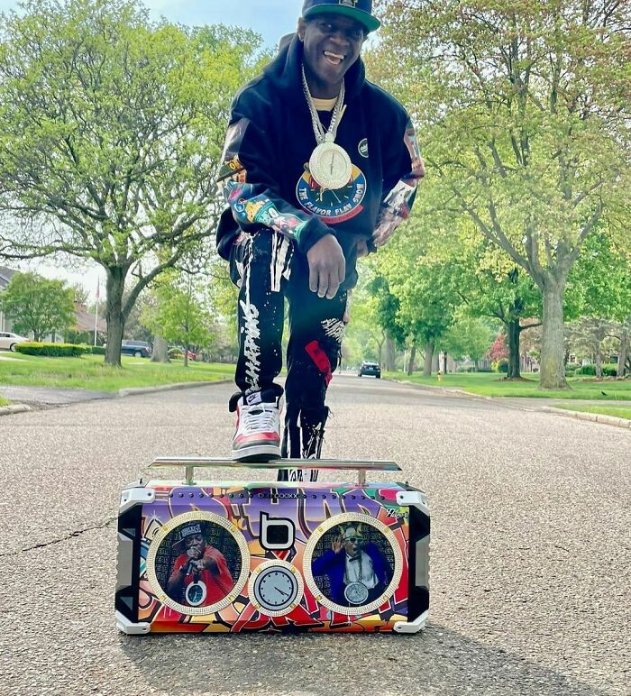 Hip hop artist posing outdoors with a colorful boombox, representing smartest celebrities known for their intelligence.