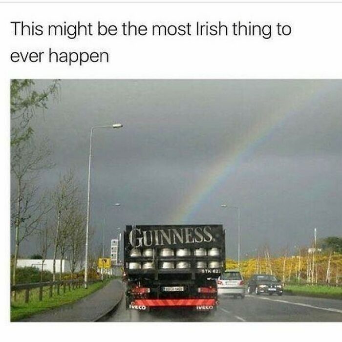 Truck carrying Guinness kegs on an Irish road under a rainbow, illustrating a unique moment in Ireland culture.