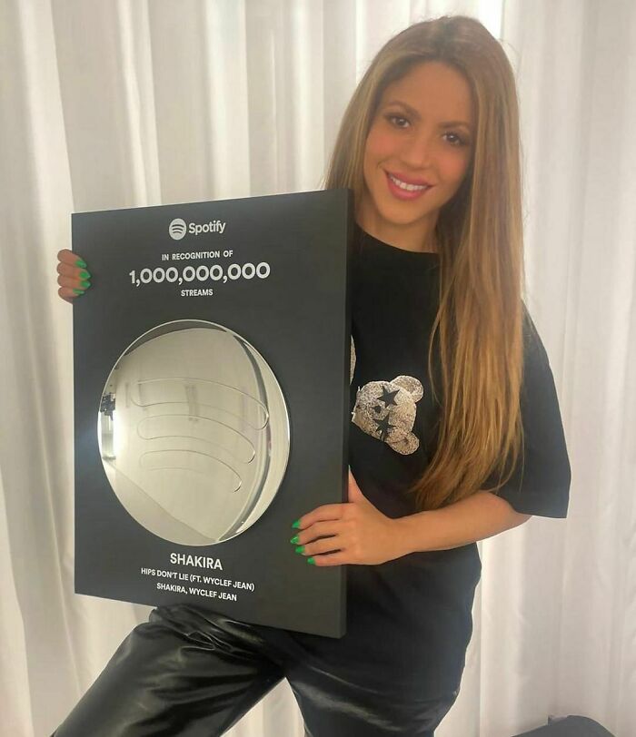 Shakira holding a Spotify plaque for 1 billion streams, representing smartest celebrities known for talent and intelligence.