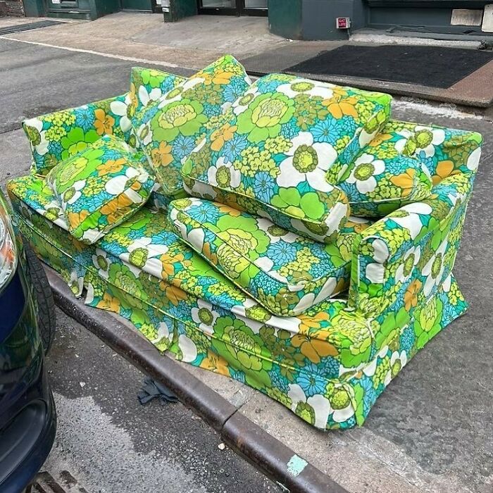 Vintage floral patterned couch found thrown away on the street, illustrating one man's trash is another man's treasure.