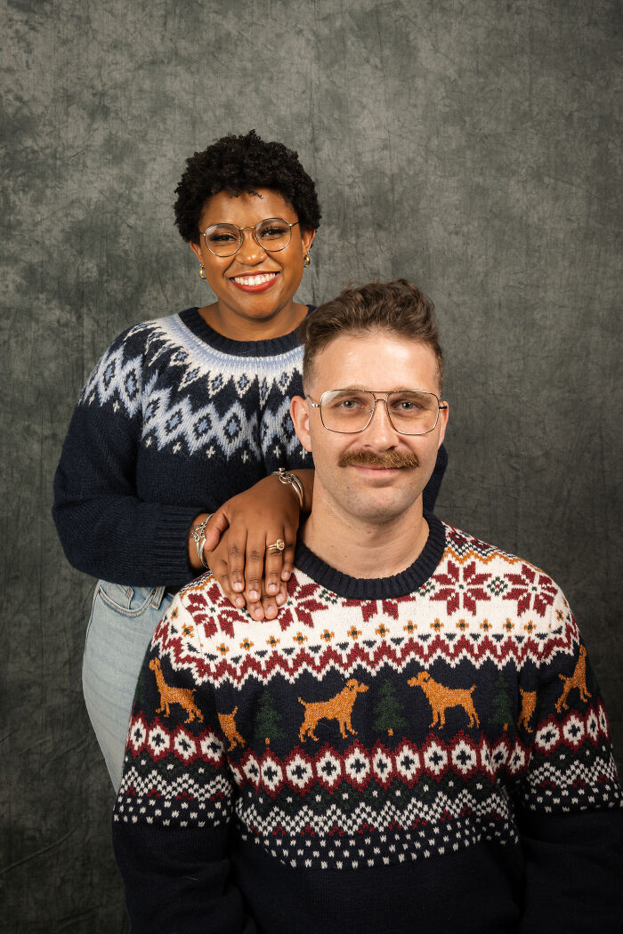 Couple posing in 80s-themed sweaters, retro photoshoot style for anniversary celebration.
