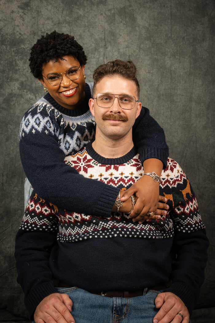 Couple wearing retro sweaters in an awkward 80s-themed photoshoot for their anniversary.