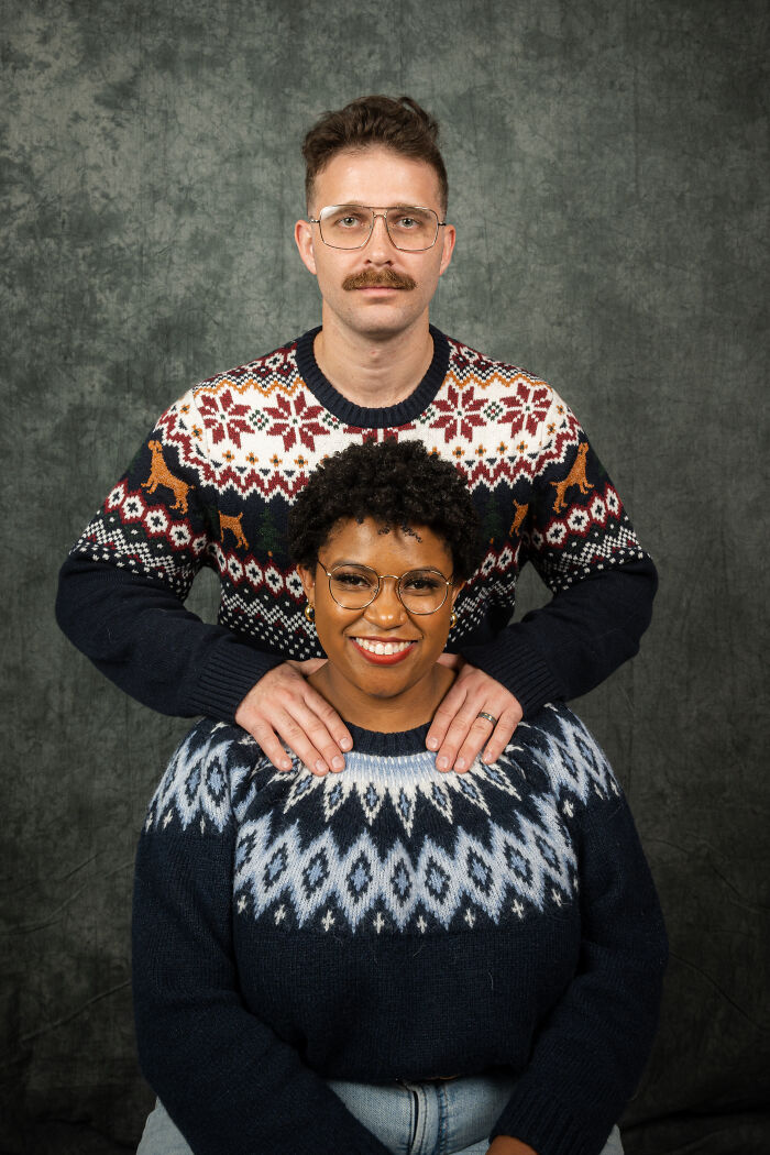 Couple in 80s-themed photoshoot, wearing vintage sweaters, celebrating their anniversary with quirky poses.