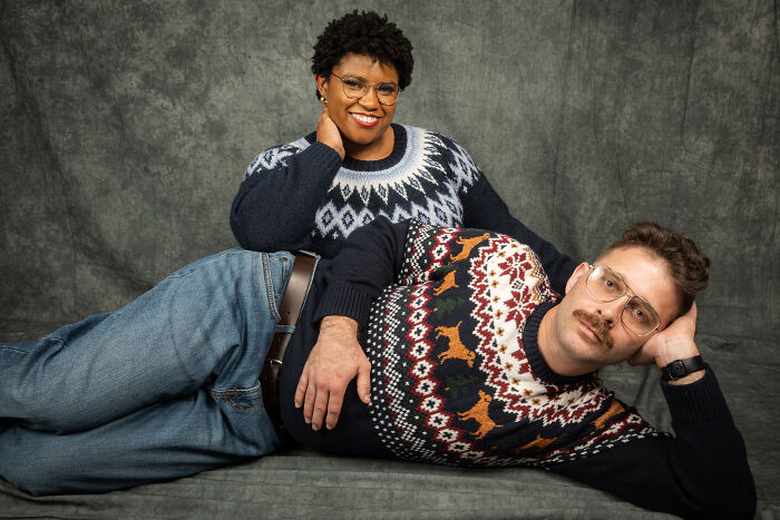 Couple posing in 80's style sweaters, with glasses and mustache, for an 80's photoshoot anniversary session.