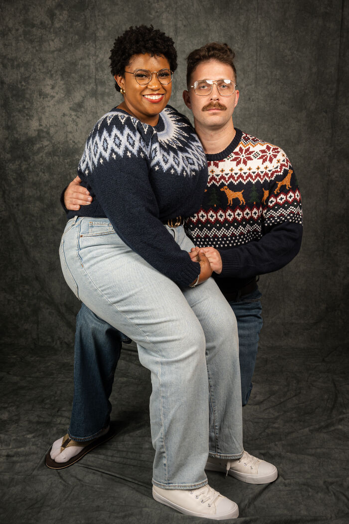 Couple posing in vintage 80s fashion, wearing retro sweaters, glasses, and jeans, celebrating their anniversary with a themed photoshoot.