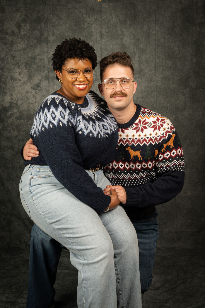 Couple in 80s-themed photoshoot wearing vintage sweaters and jeans.