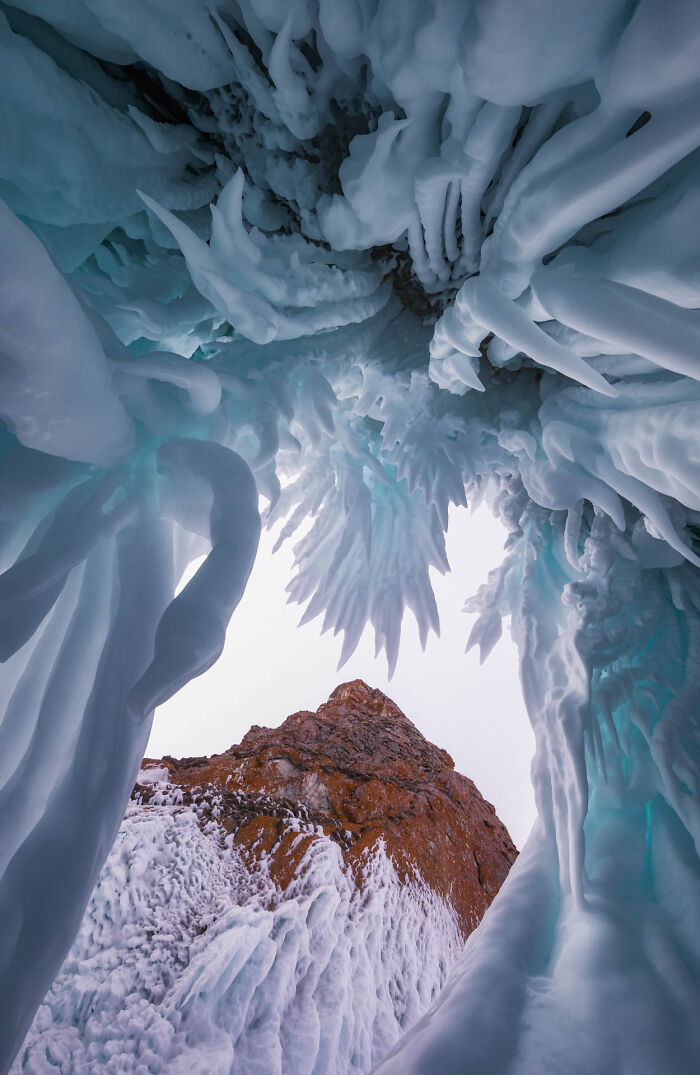 Frozen icicles and snow framing a rocky mountain peak in a winning picture from Nature Photographer of the Year 2022.
