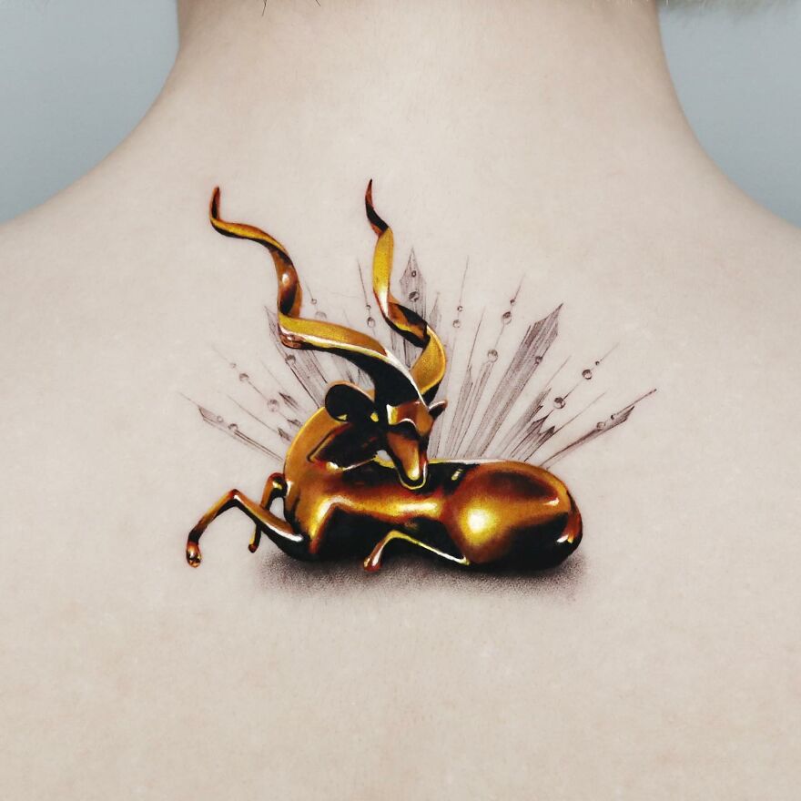 Golden tattoo of a stylized antelope on skin, crafted by a Manhattan-based tattoo artist.
