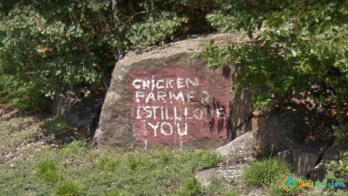 Graffiti on a rock reading I still love you to chicken farmer, an amusing moment captured by Google Maps.