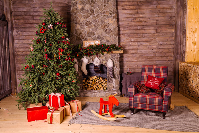 Room with decorated Christmas tree, presents, sofa and fireplace