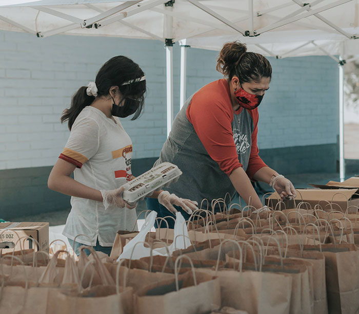 Persons putting food in paper bags