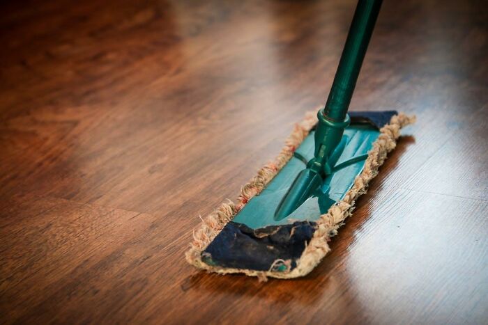 Mop cleaning wooden floor, illustrating common things basically everyone does but pretend not to in daily life.