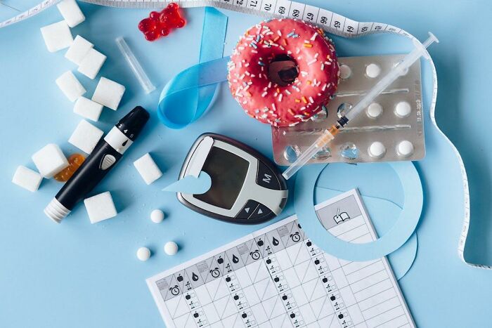 Diabetes testing supplies, sugar cubes, donut, and measuring tape illustrating criminally overpriced medical items.