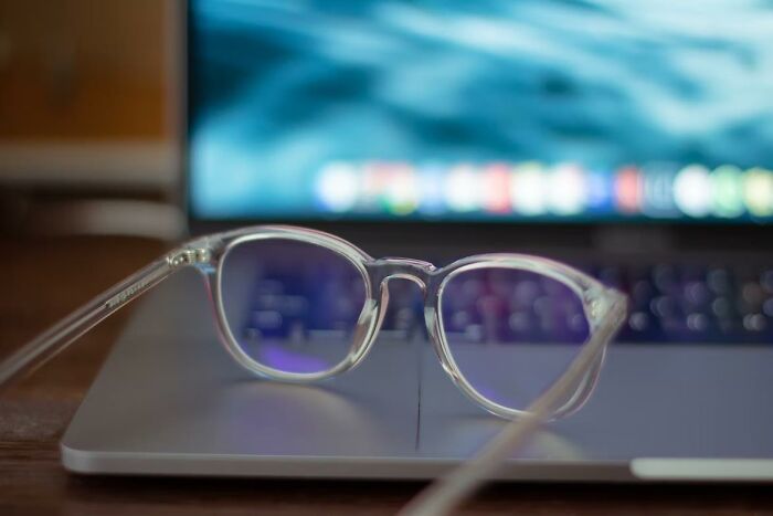 Clear eyeglasses resting on a laptop keyboard, illustrating the concept of something criminally overpriced.