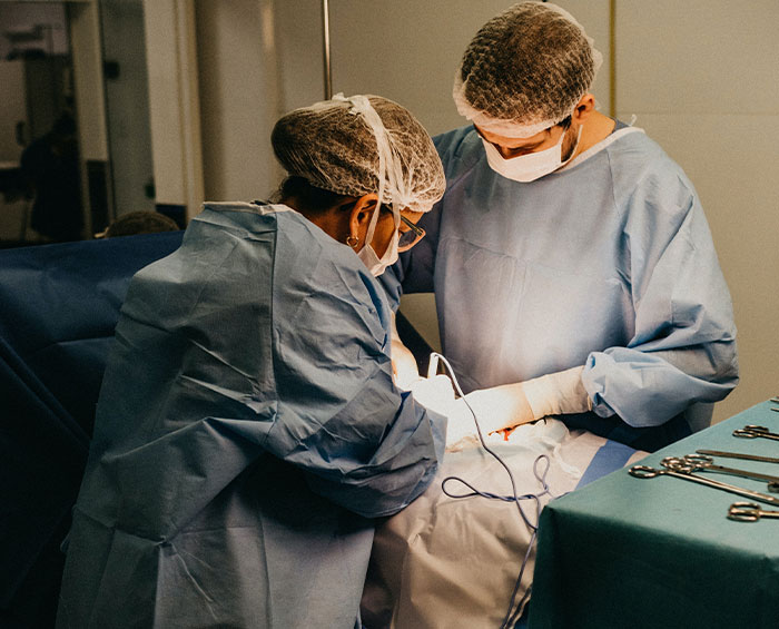 Two doctors in surgical gowns and masks performing a procedure, highlighting second opinion importance in medical care.