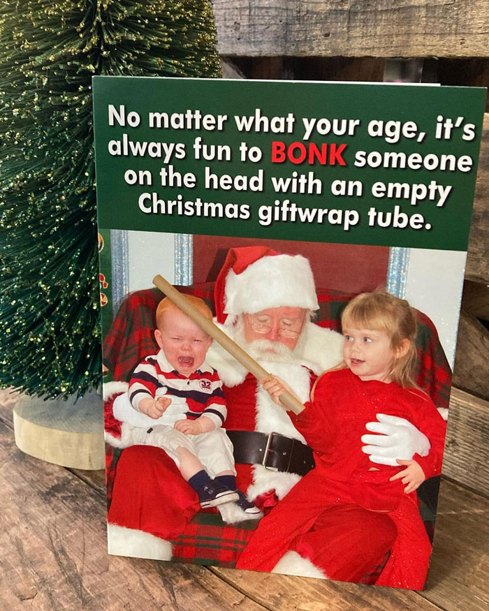 Funny Christmas card with Santa and kids, one playfully holding an empty giftwrap tube.