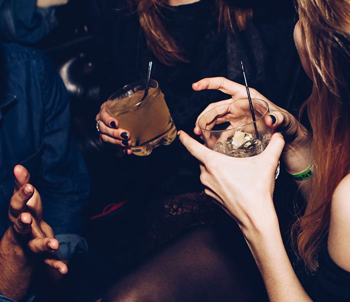Persons holding drinks at party